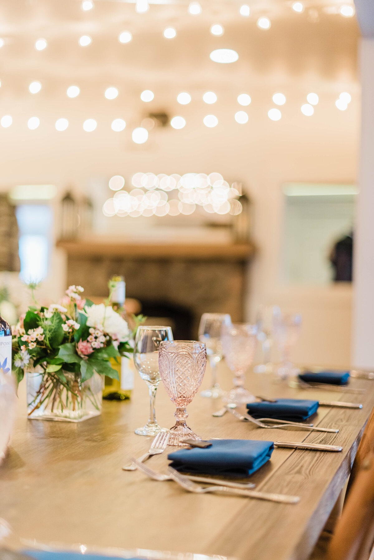 Denver wedding photographer captures reception table details with a navy napkin and pink champagne glasses