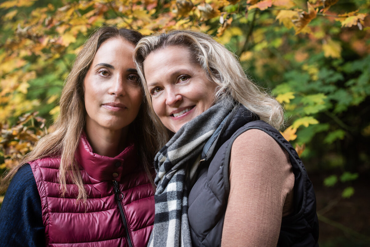 Two women standing close smiling.
