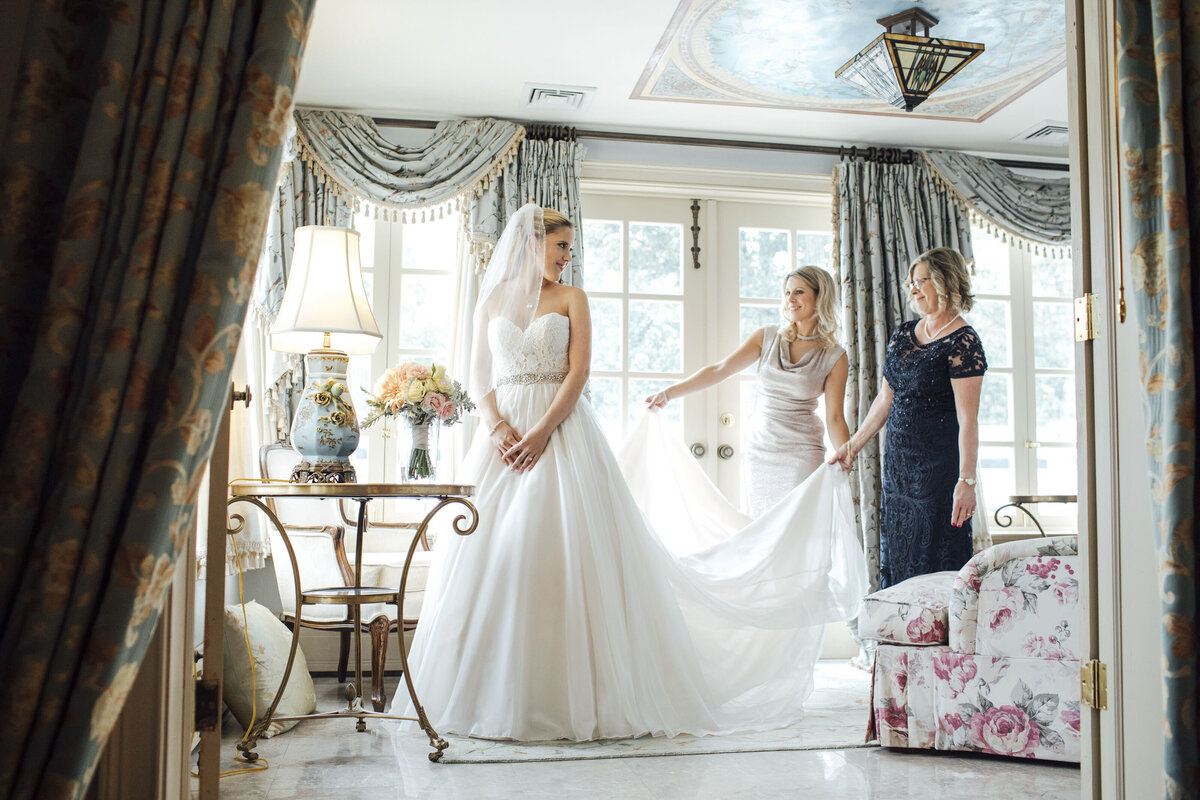 The Inn at Barley Sheaf | Bride getting into dress with mom and sister in bridal suite | Holicong, Pennsylvania