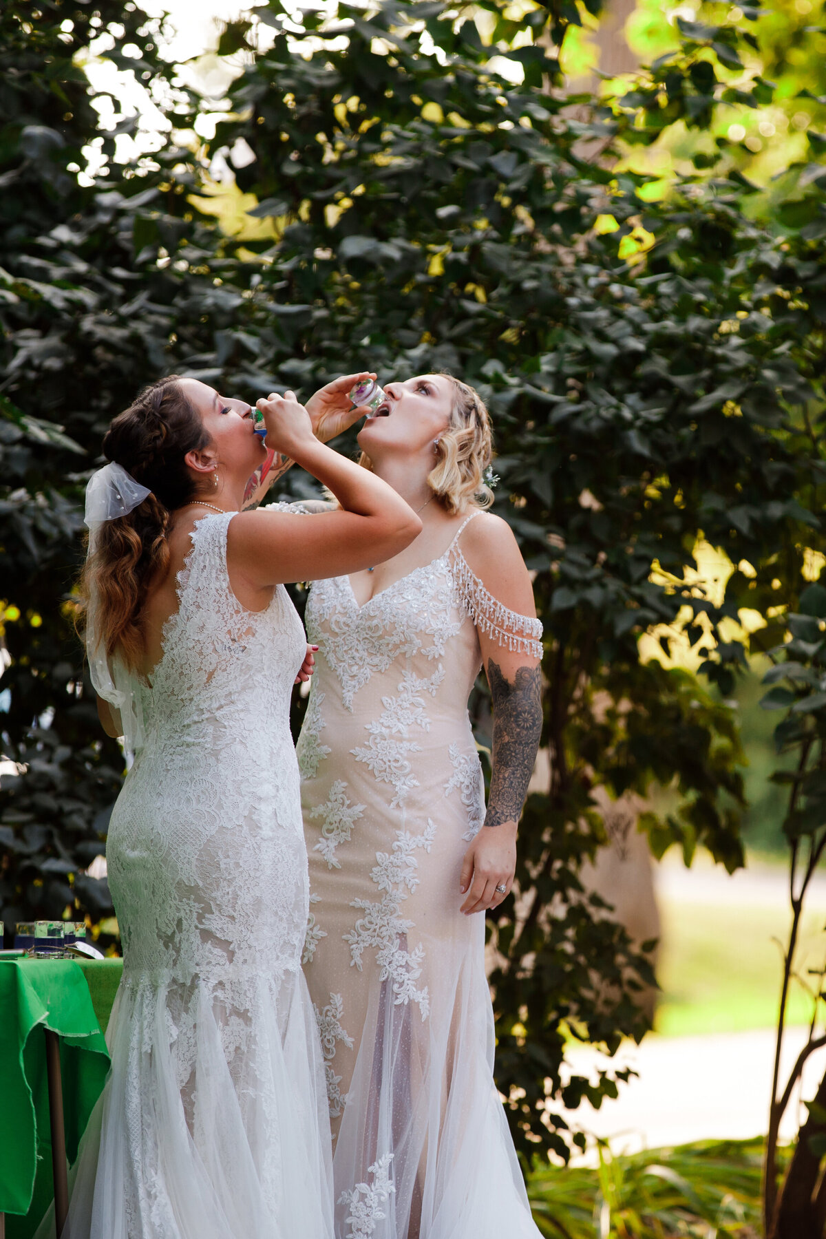LGBTQ+ couple taking shots on their wedding day