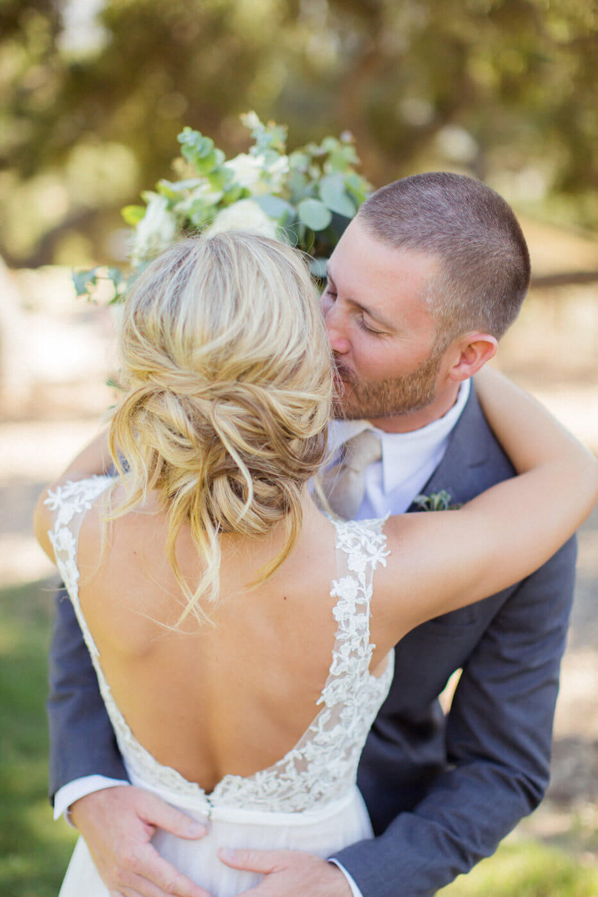 Groom kissing the cheeks of the bride