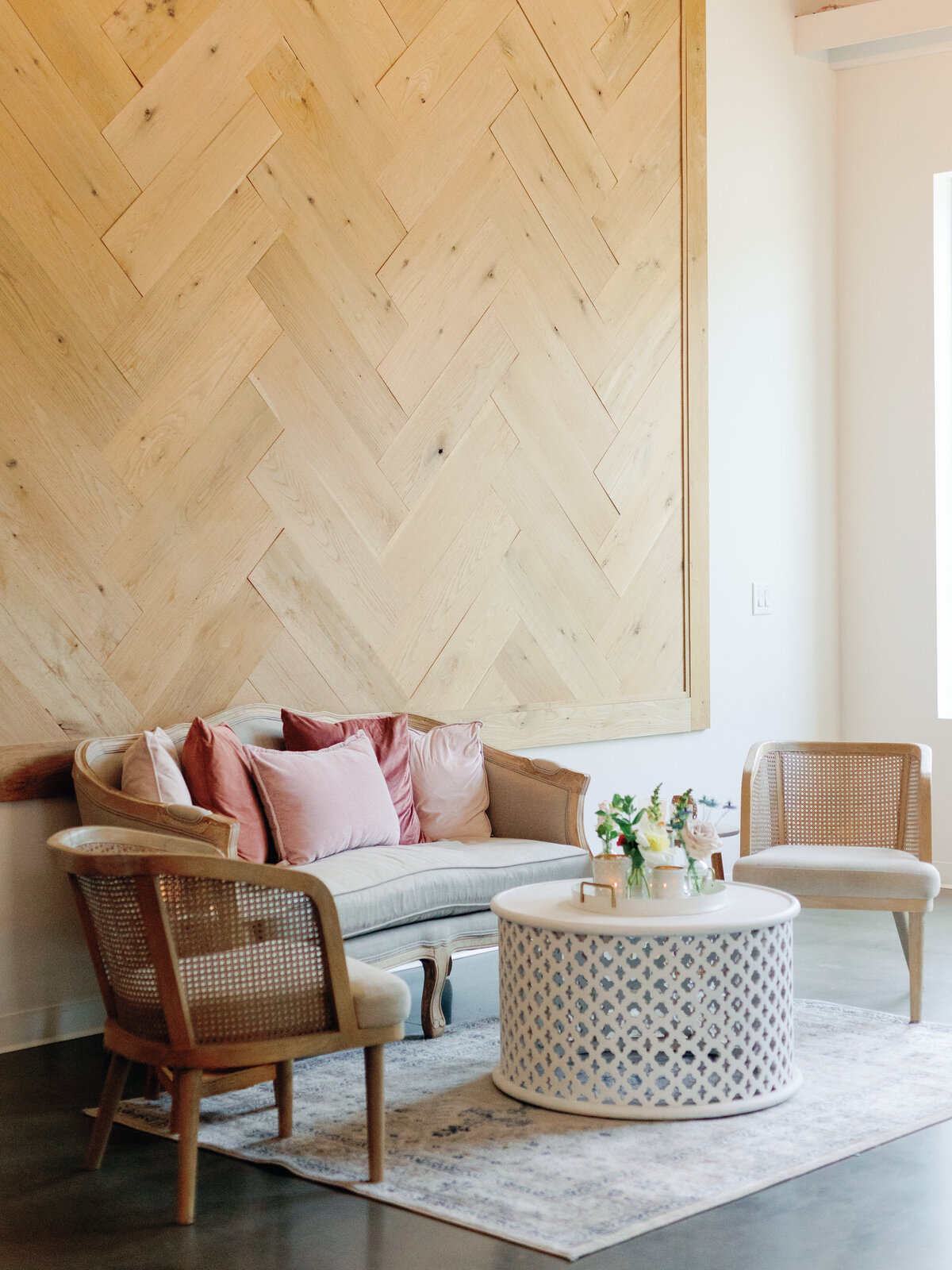 pink and white lounge set in front of herringbone wall