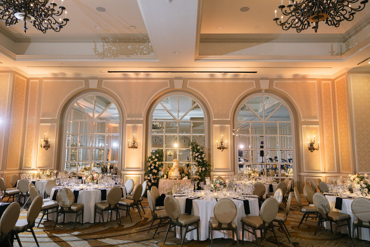 wide-angle view of the wedding reception at The Adolphus in Dallas, featuring elegantly decorated tables with floral centerpieces and candlelight.