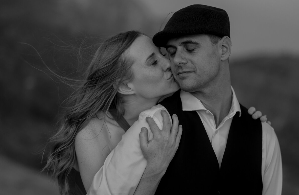 Couple standing against red rock backdrop during Sedona engagement session