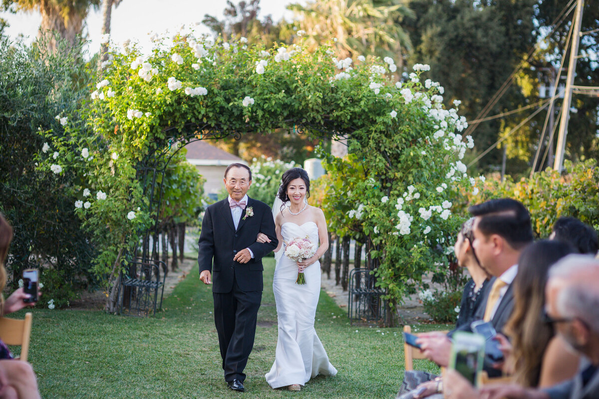 bride being walked down the aisle by her dad