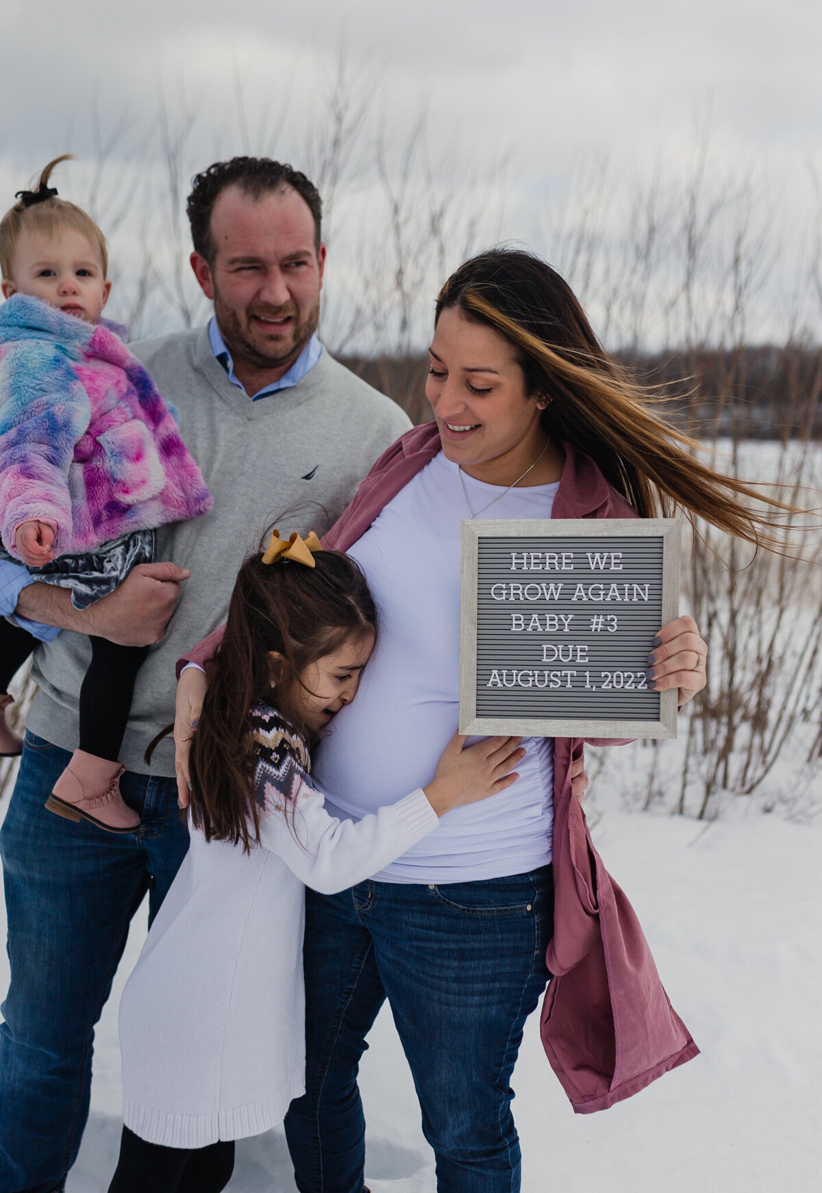 Pregnancy announcement family photoshoot outside.