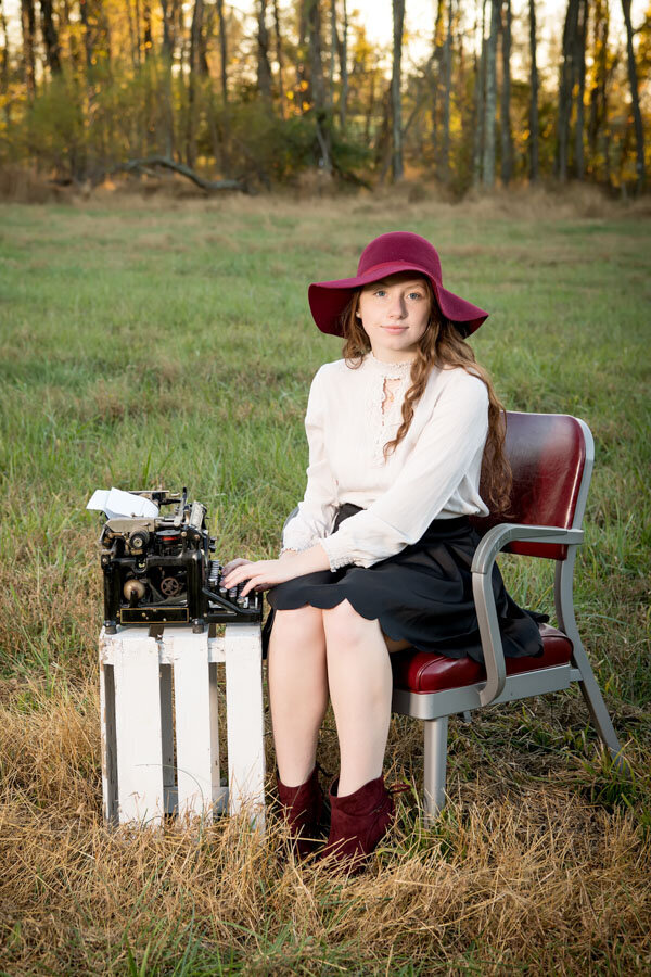 journalism girl in field with vintage typewriter
