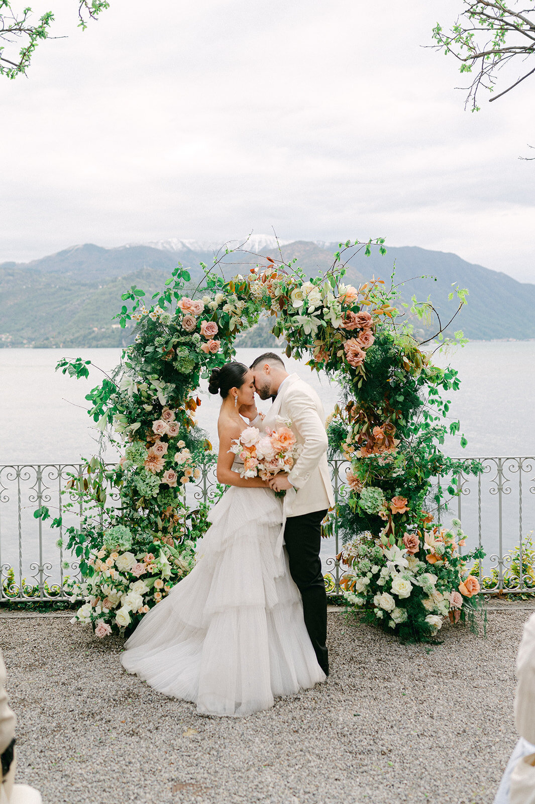 Bride and Groom kiss during wedding ceremony on Lake Como.