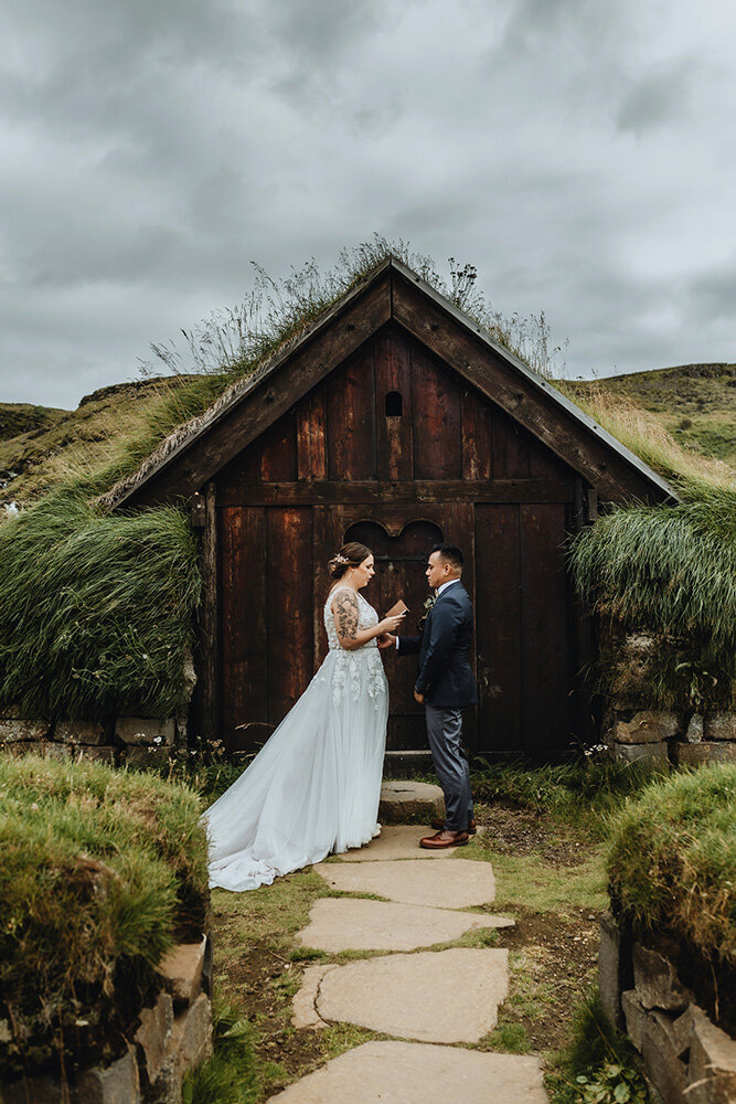 Romantic elopement photo of a couple embracing in front of Iceland’s famous Black Church, their silhouettes painting a picture of timeless love.