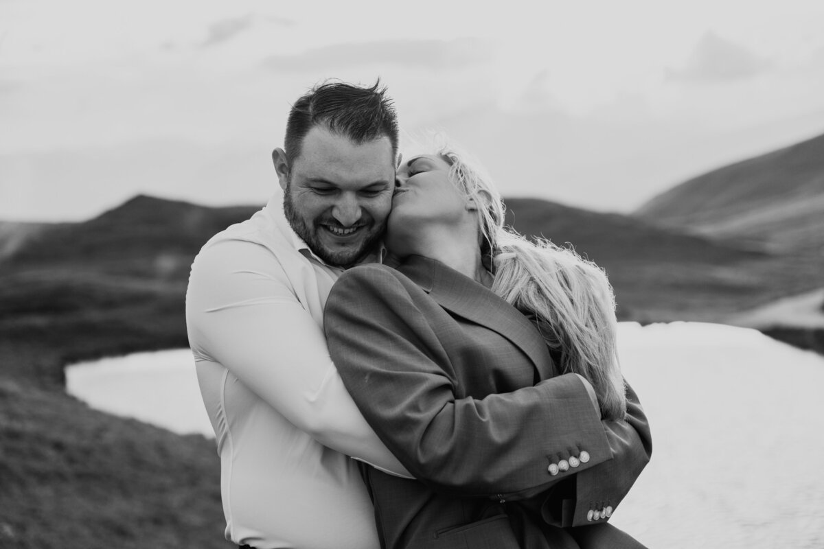 Black and white portrait of couple hugging in the mountains