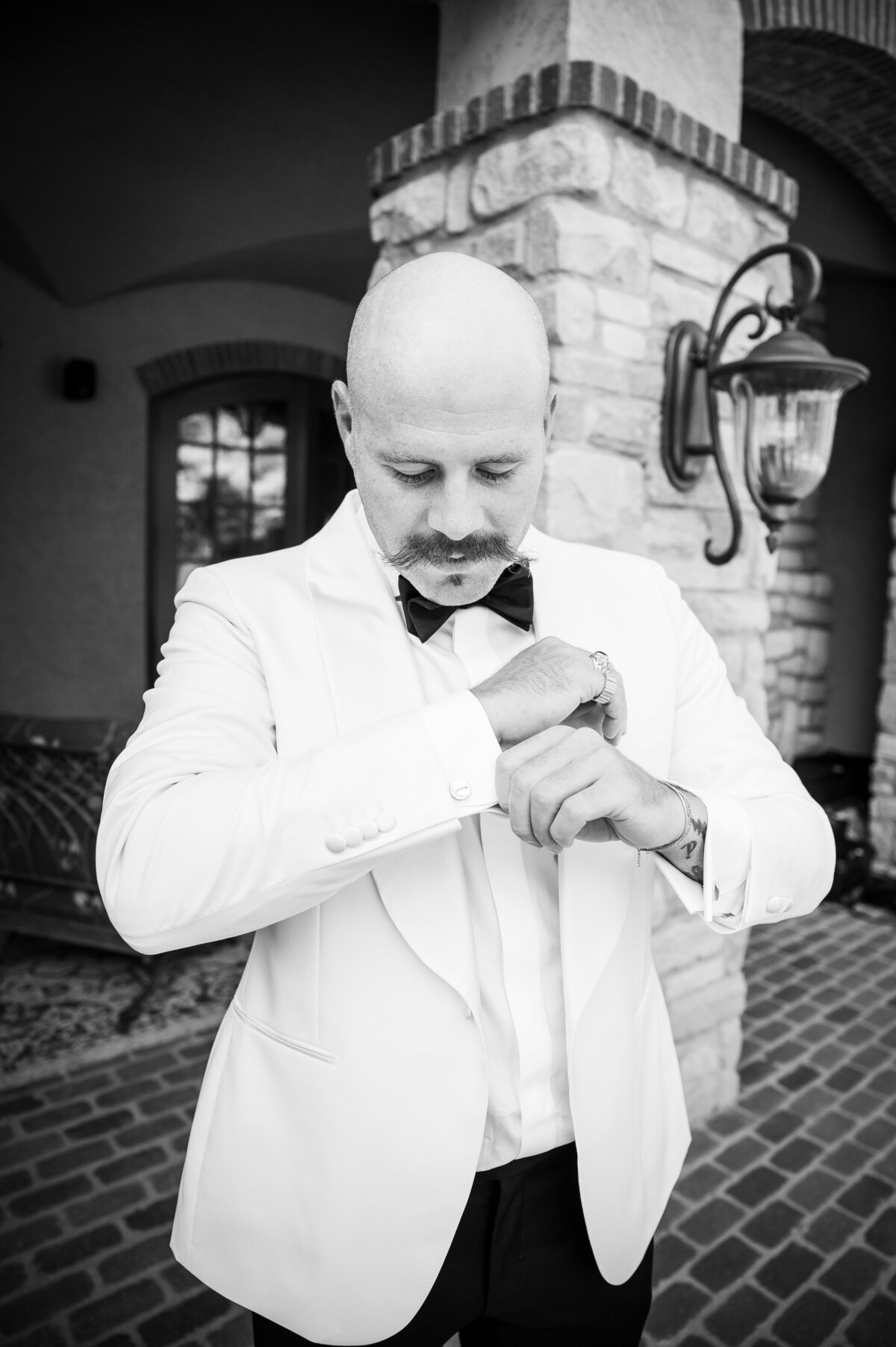 A groom adjusts his cufflinks.
