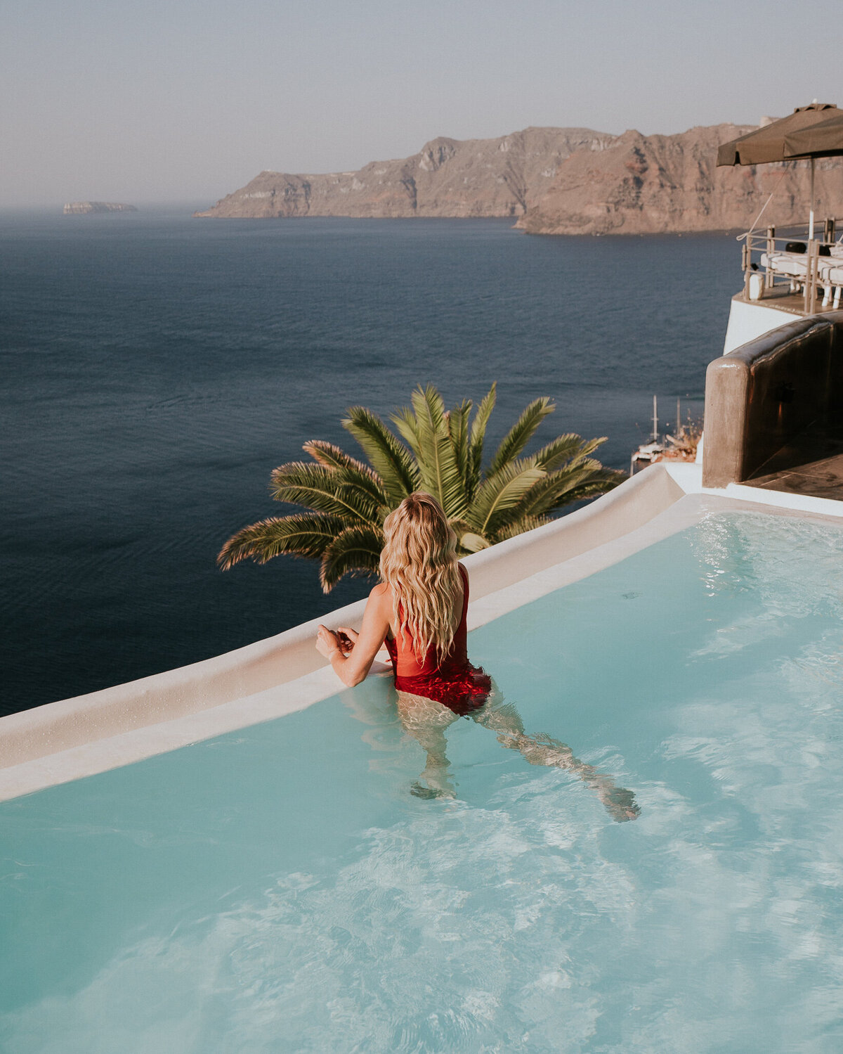 girl-luxury-hotel-pool-santorini-greece