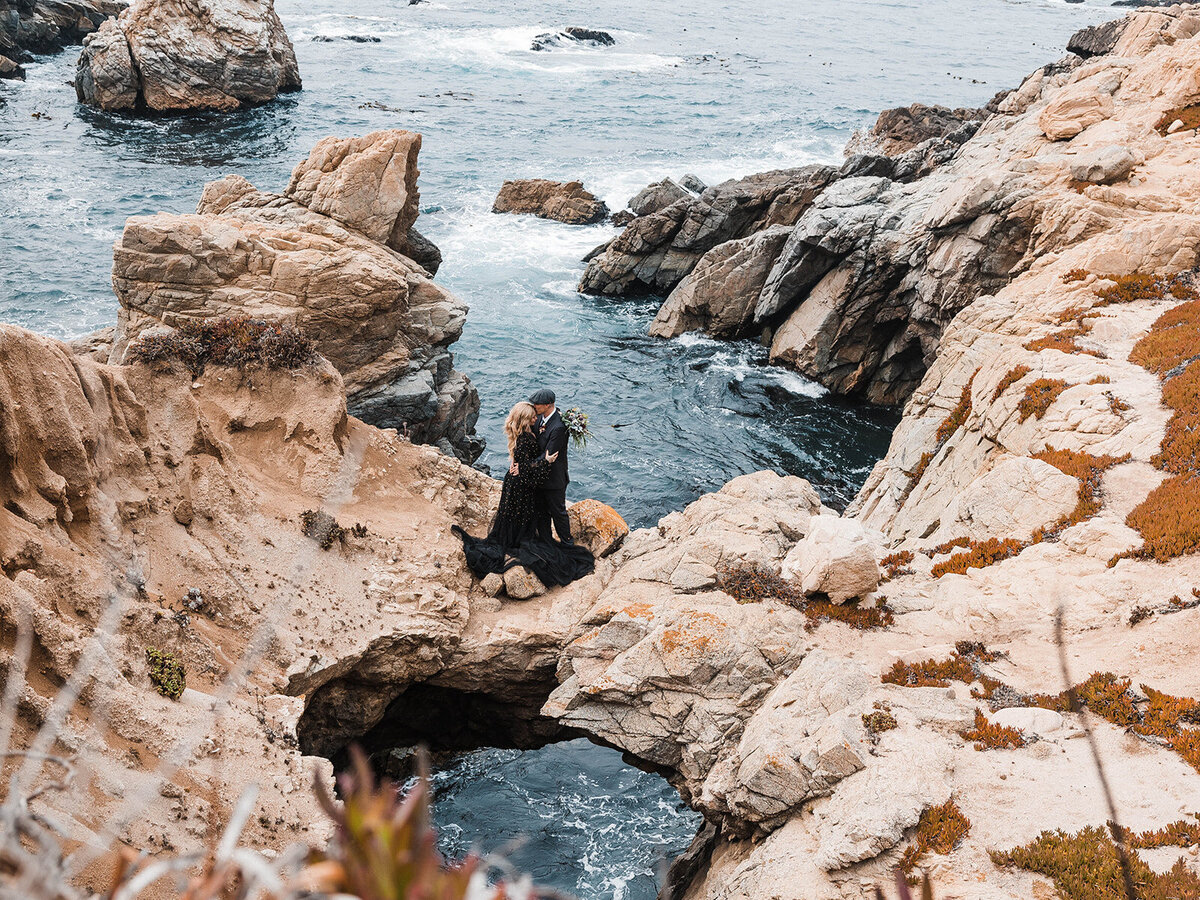 A couple celebrating their romantic elopement amidst the breathtaking coastal scenery of Big Sur, California. Captured by a premier California elopement photographer, this image showcases the wild beauty and intimate moments of a perfect Big Sur elopement.