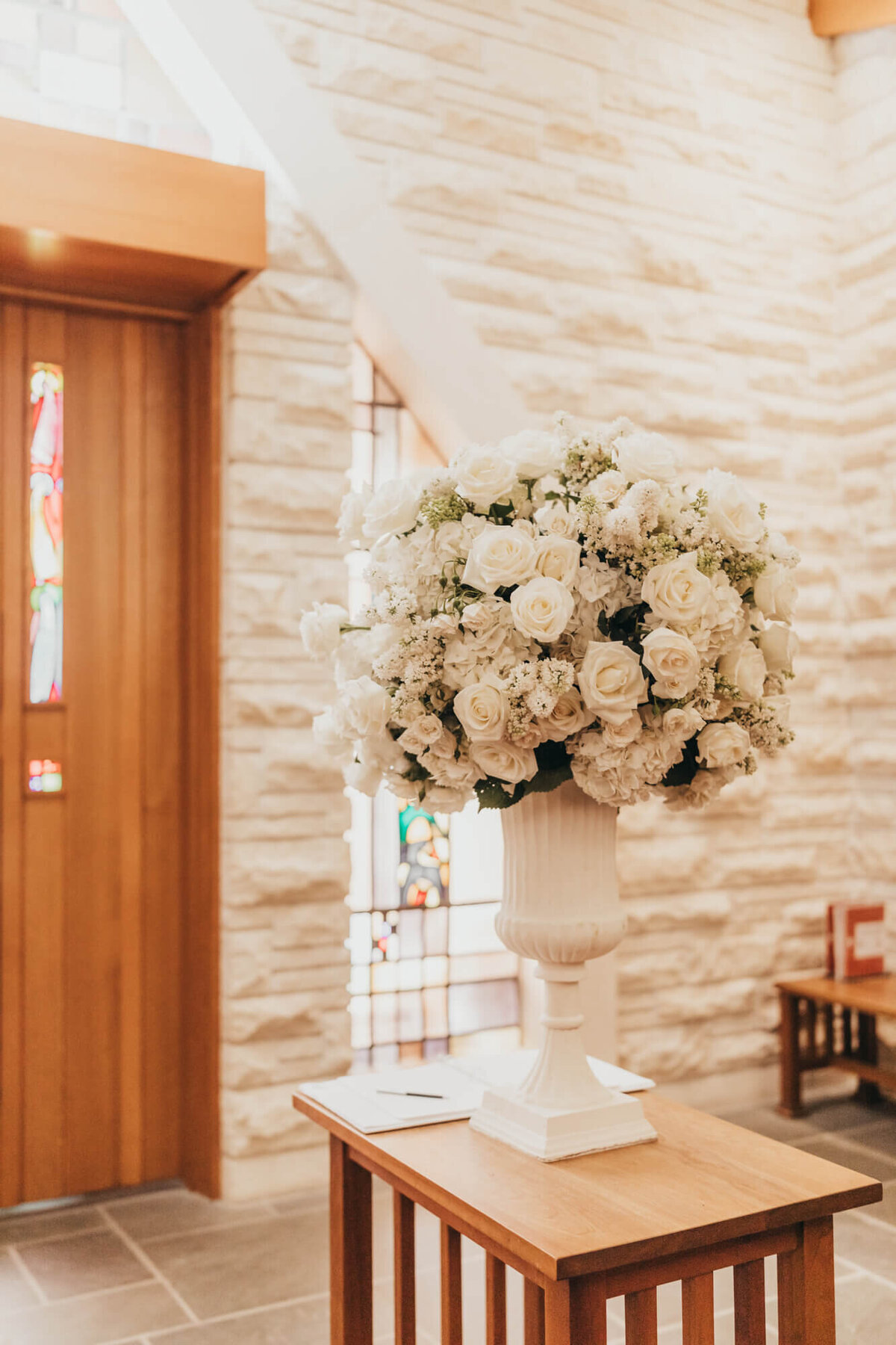 white floral arrangement at the church, with guestbook.