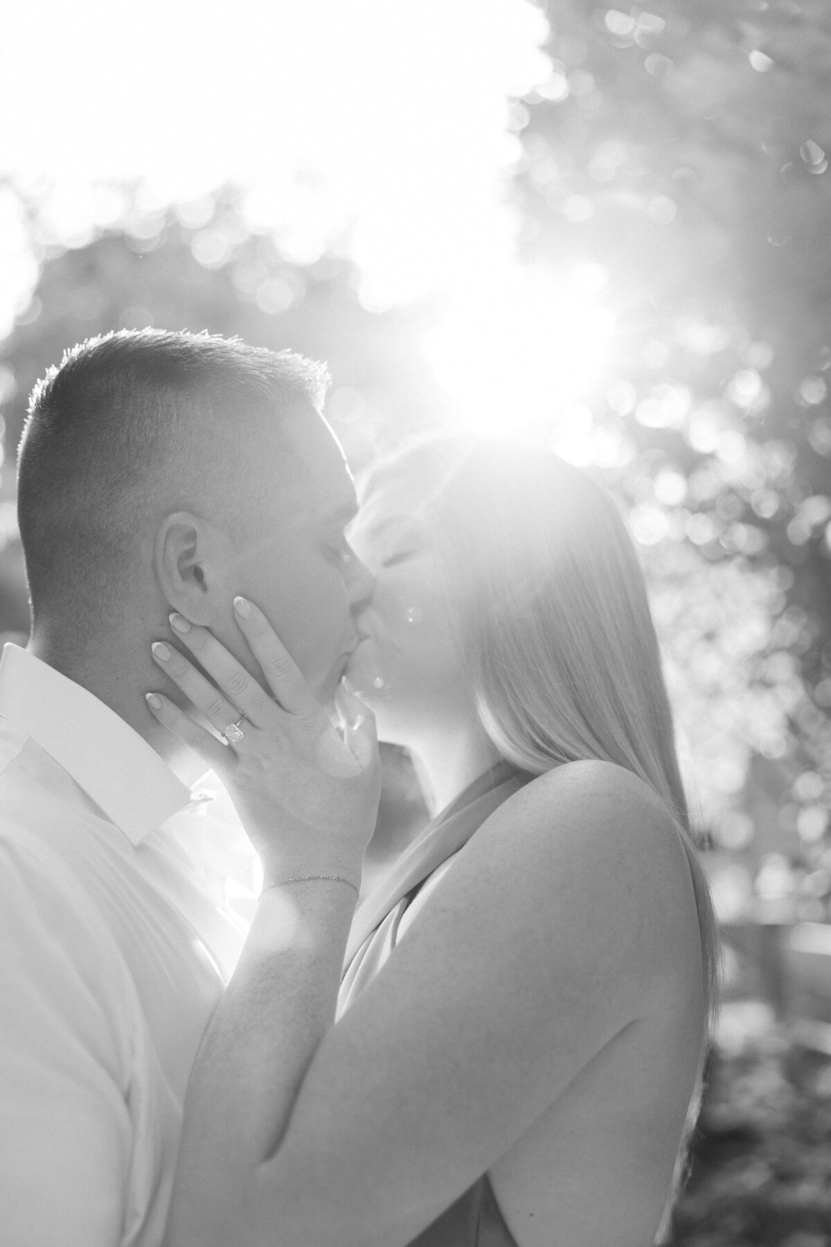 Black and white image of engaged couple kissing in sunny Columbus session by Philadelphia photographer.
