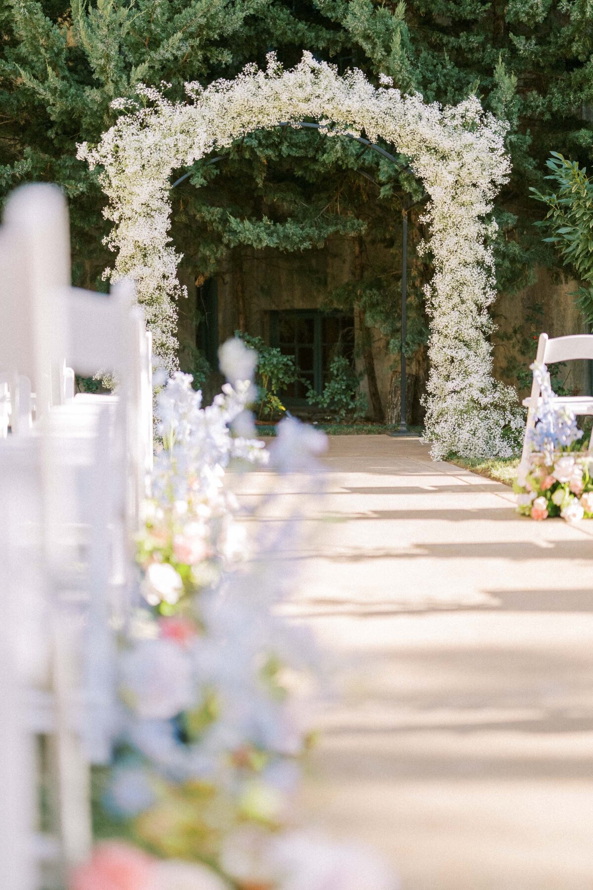 baby-breath-arbor-with-flowers-lining-aisle