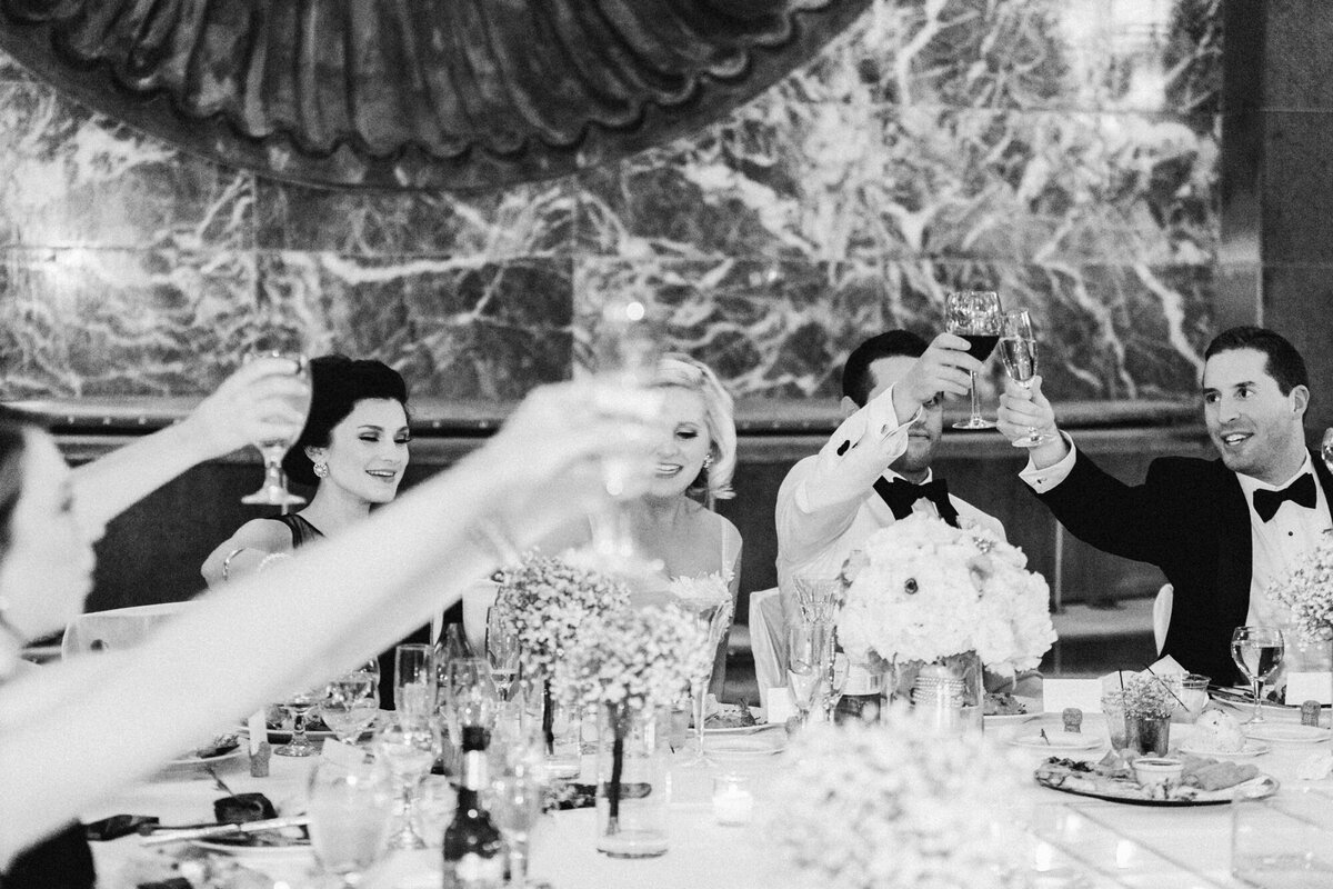 Bride and groom clink glasses during wedding reception toasts
