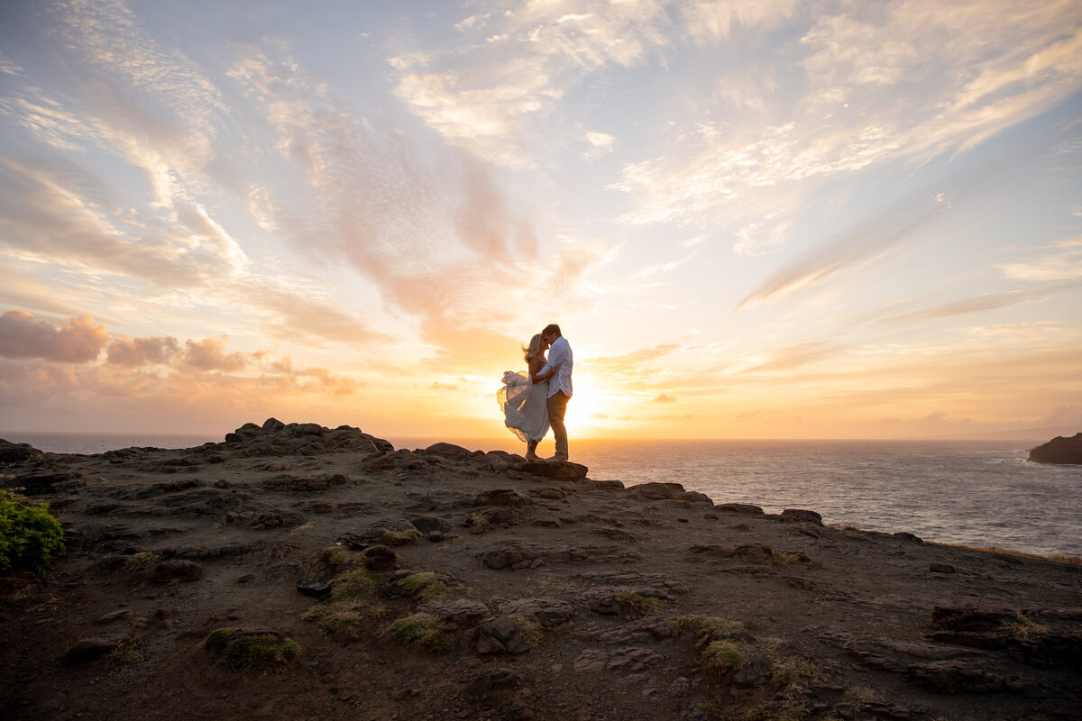 Hawaii Engagement Photographer captures couple embracing at sunset during beach engagement photos