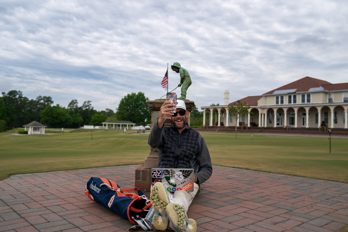 Social Media Golf Influencer Matt Cardis aka Golf In Your State sitting below Putter Boy Statue creating an Instagram Reel at Pinehurst Number 2 early in the morning May 2020.