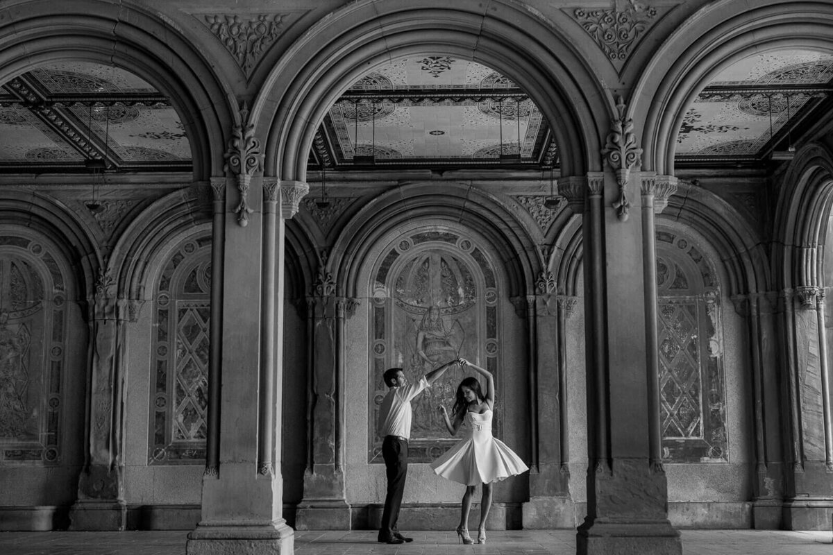 The engaged couple is dancing inside Bethesda Terrace in Central Park. Image by Jenny Fu Studio.