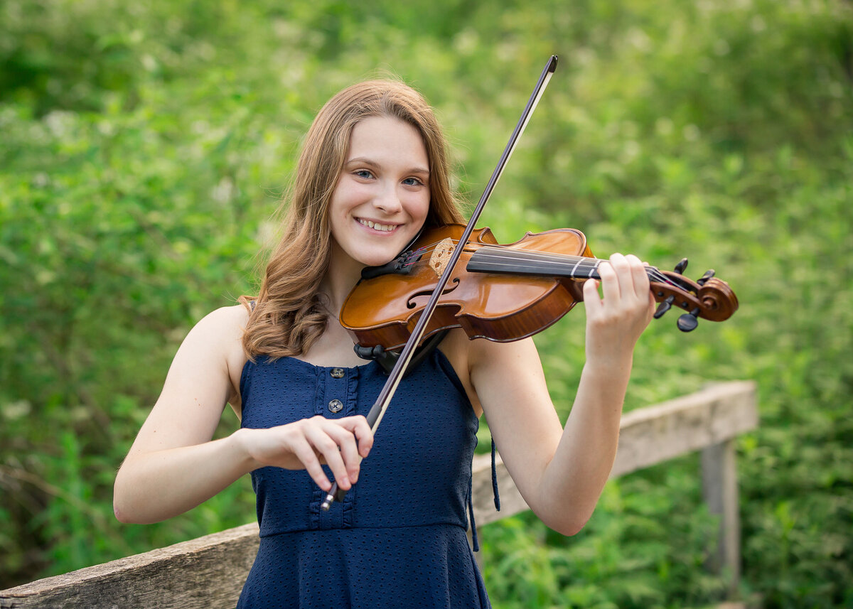 girl playing the violin in a serene farm setting 