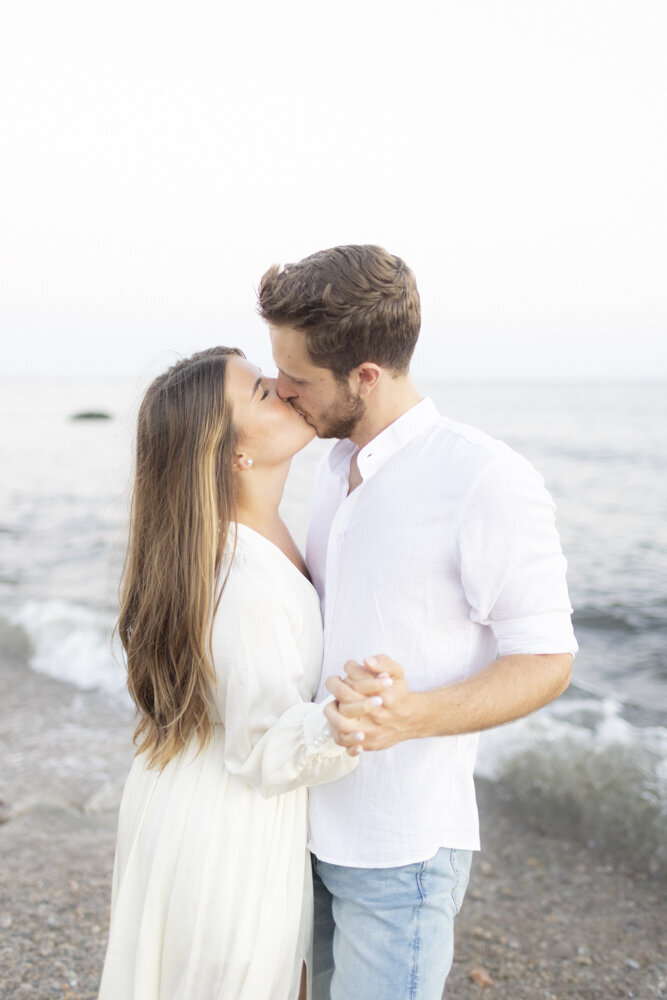 couple kissing on the beach during engagement session