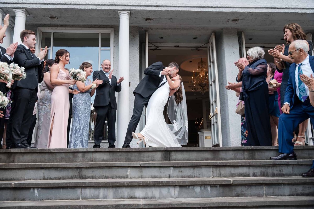 Groom dipping bride right outside their church in West Palm Beach captured by Palm Beach Wedding photographer
