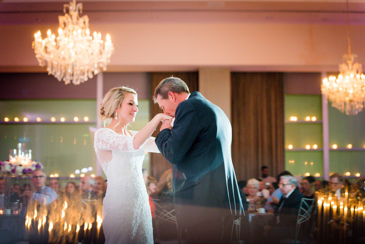 bride and dad dancing together at fairmont hotel ballroom pittsburgh where he kisses his hands after they dance