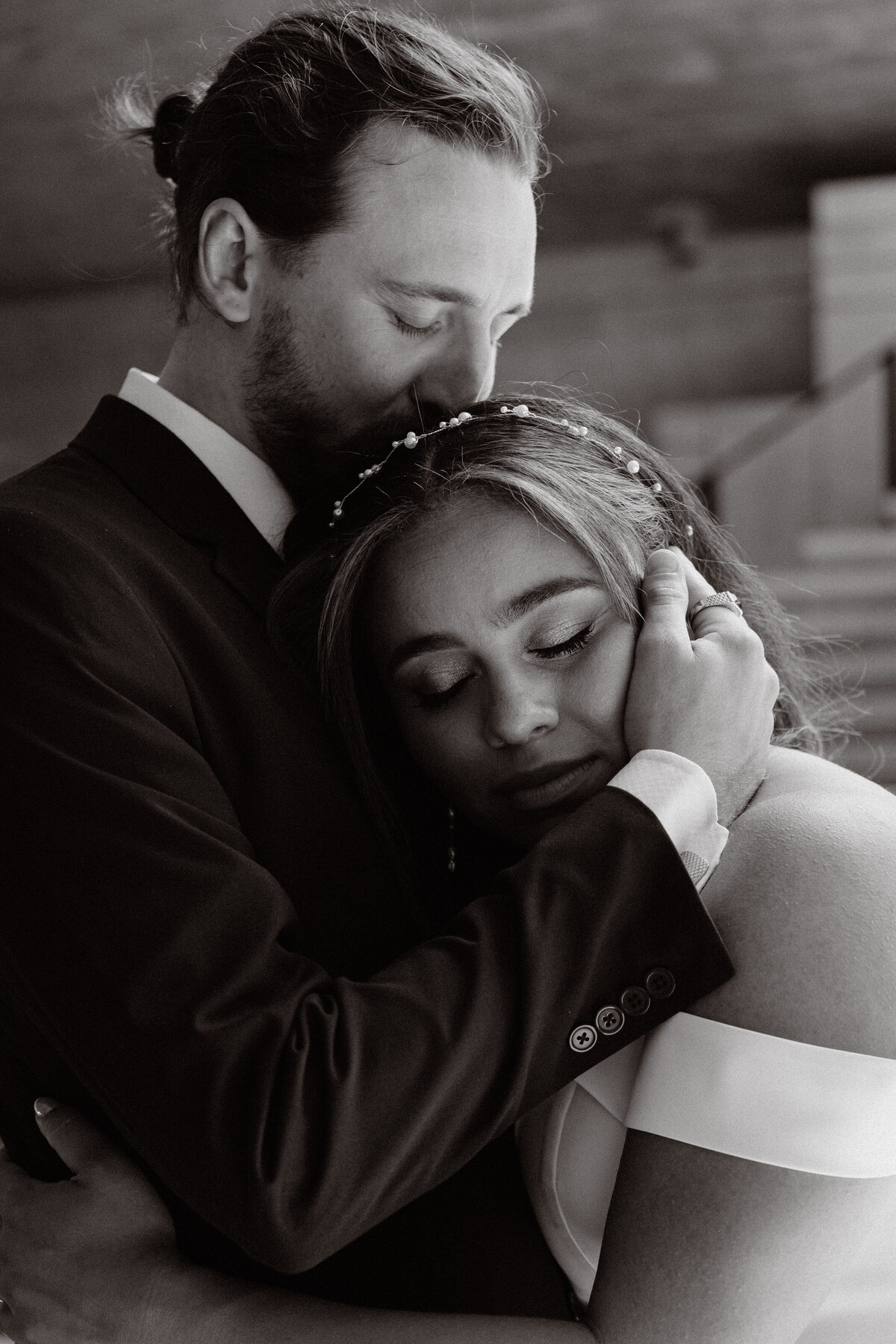 bride and groom embrace each other tightly