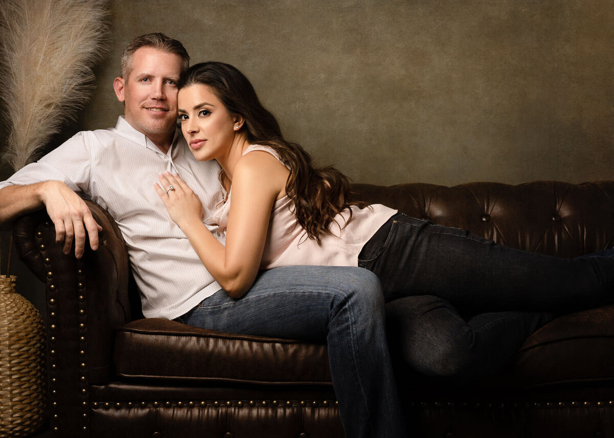 Portrait of a couple embracing on a couch, capturing a relaxed and affectionate moment in a cozy setting.