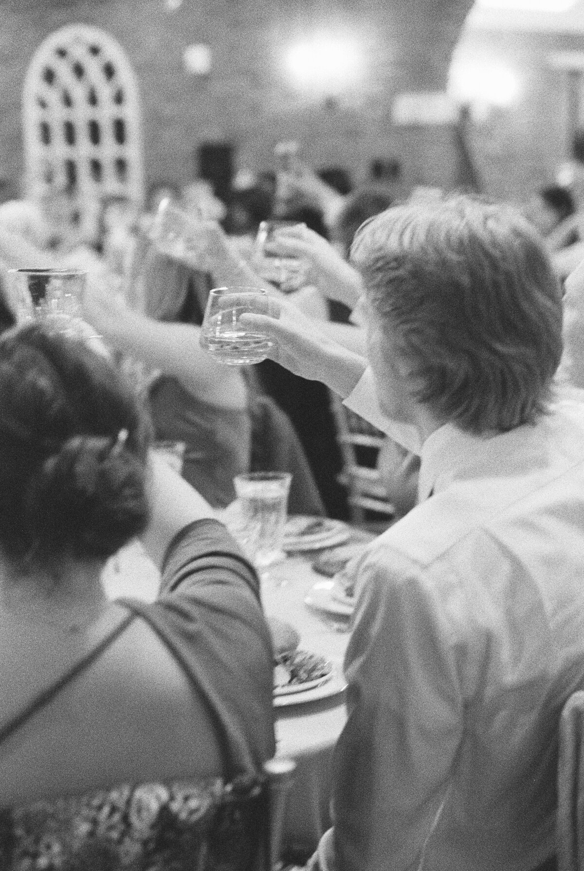 Wedding at the Estate at River Run in Maidens, VA | Wedding Photographer in Richmond | black and white film image of guests raising their glasses to toast the bride and groom at their wedding reception in RVA