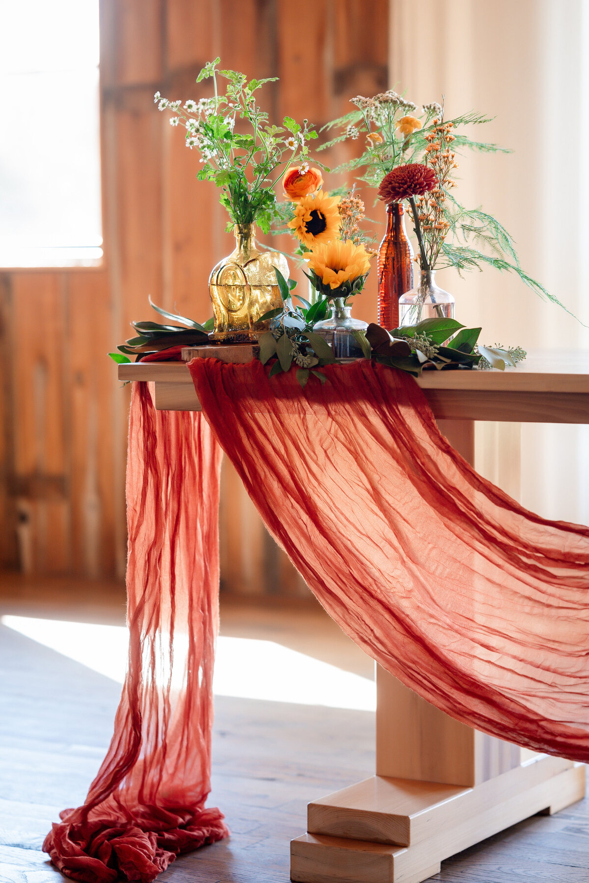 wedding design of head table with burnt orange drapery and sunflowers