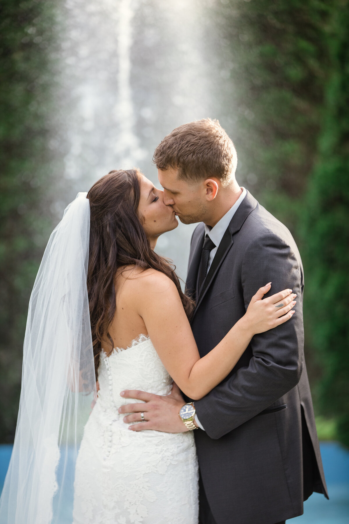 photo of bride and groom kissing near fountain at The Carltun