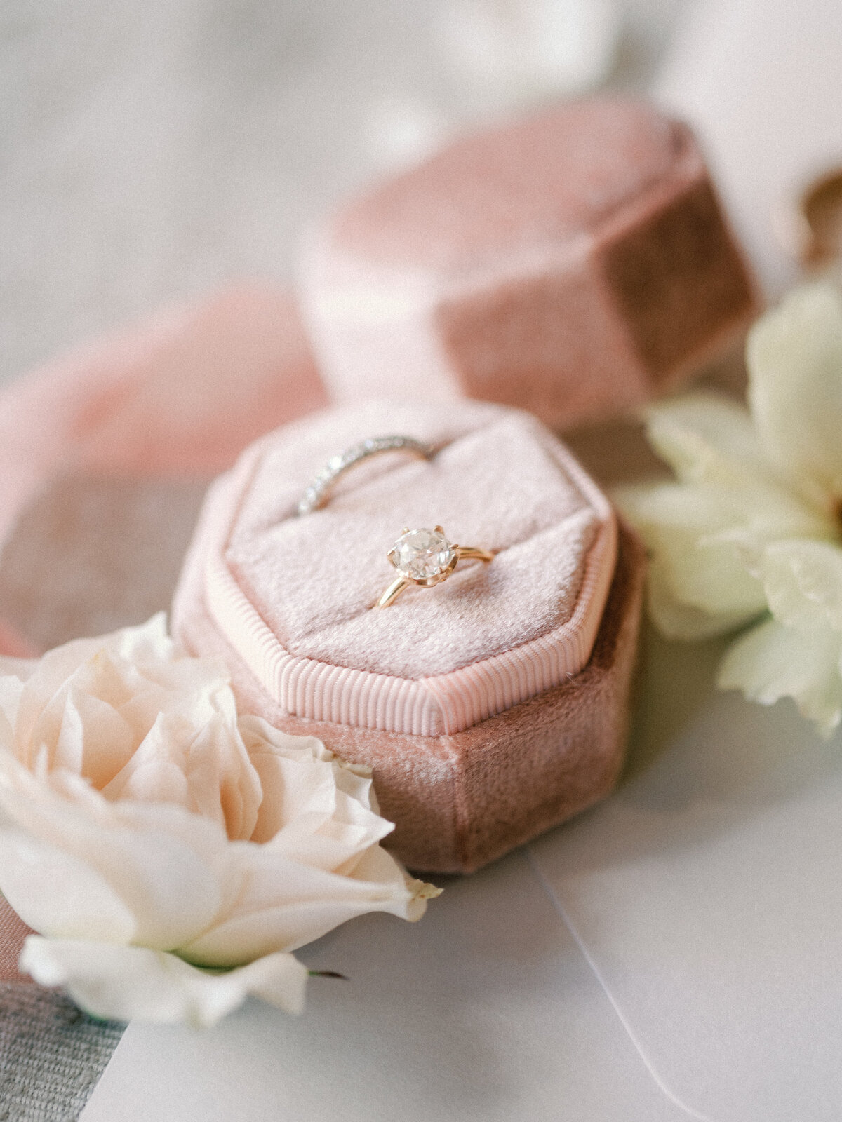 bride ring and wedding band details flat lay with flowers