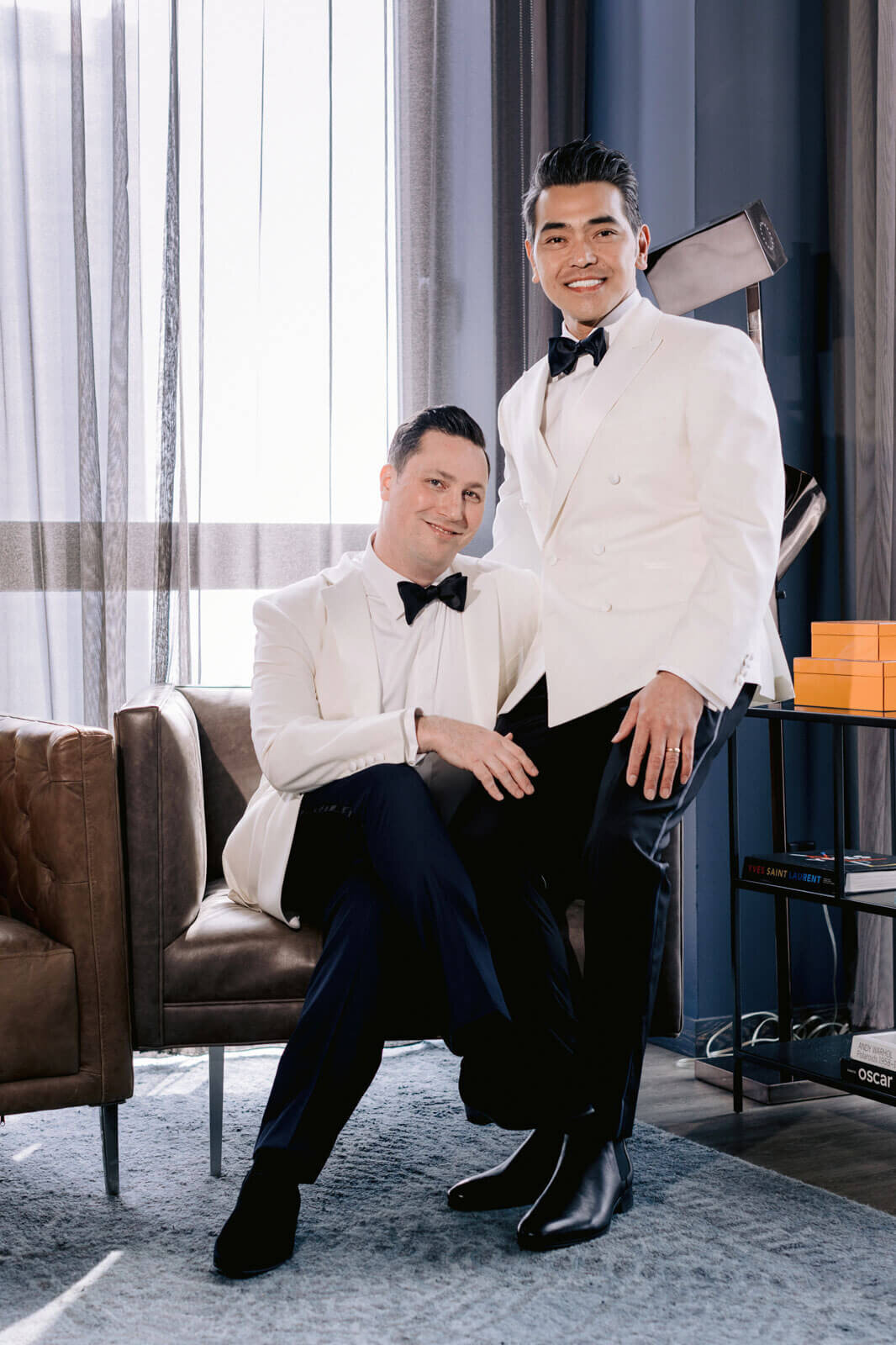The grooms are wearing white suits and black bow tie in The Skylark, New York. Wedding Image by Jenny Fu Studio