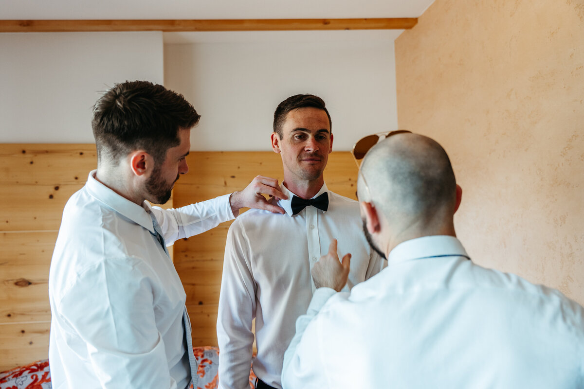 Groom adjusting bow tie before ceremony