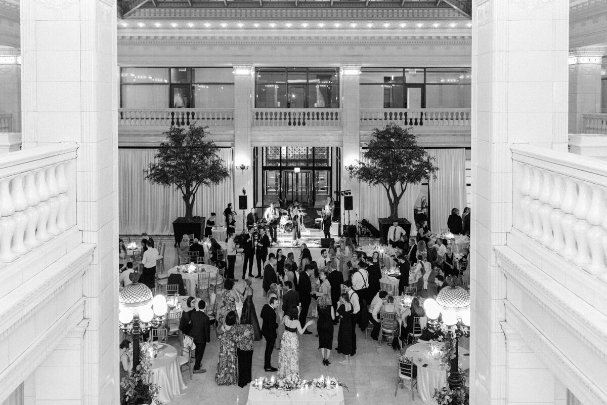 A wide black and white wedding photo capturing the lively dance floor at The Exchange, filled with guests celebrating.