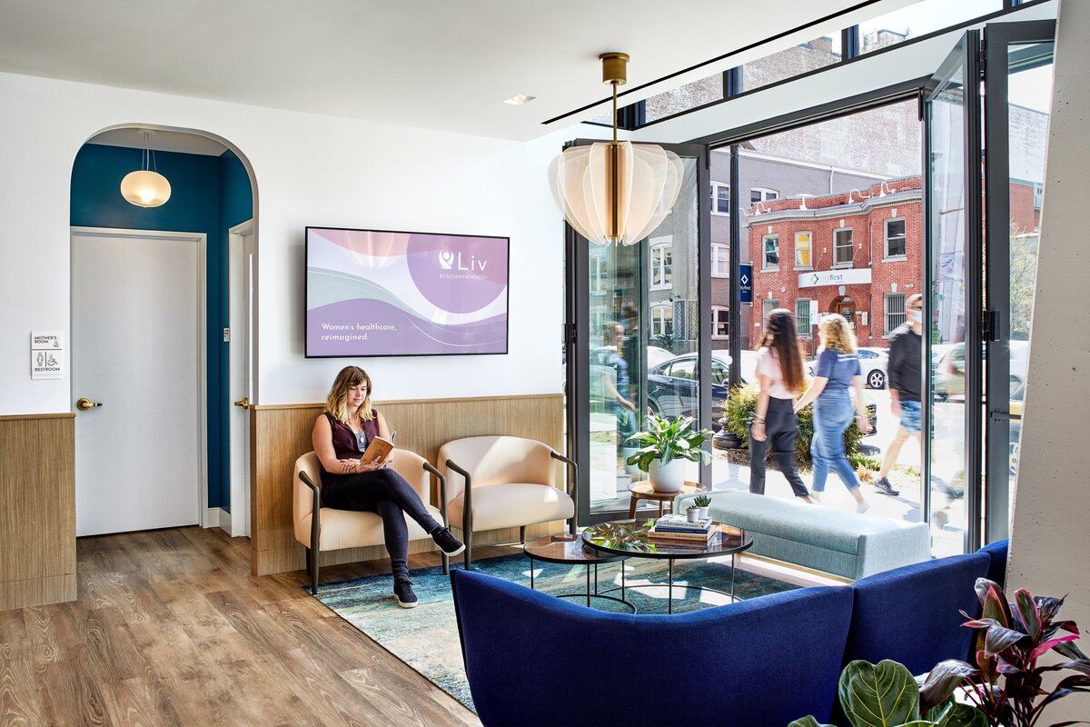A woman sits in the modern health clinic, Liv by Advantia Health, an example of Courtney's branding, interior design, and creative direction experience