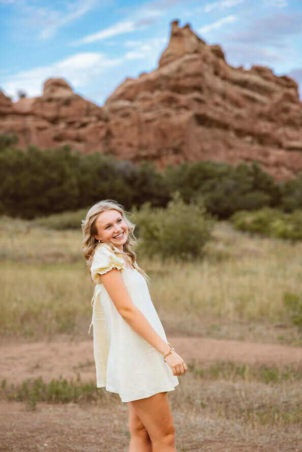 Senior girl looks over shoulder during her senior session with Angela Marie Media.