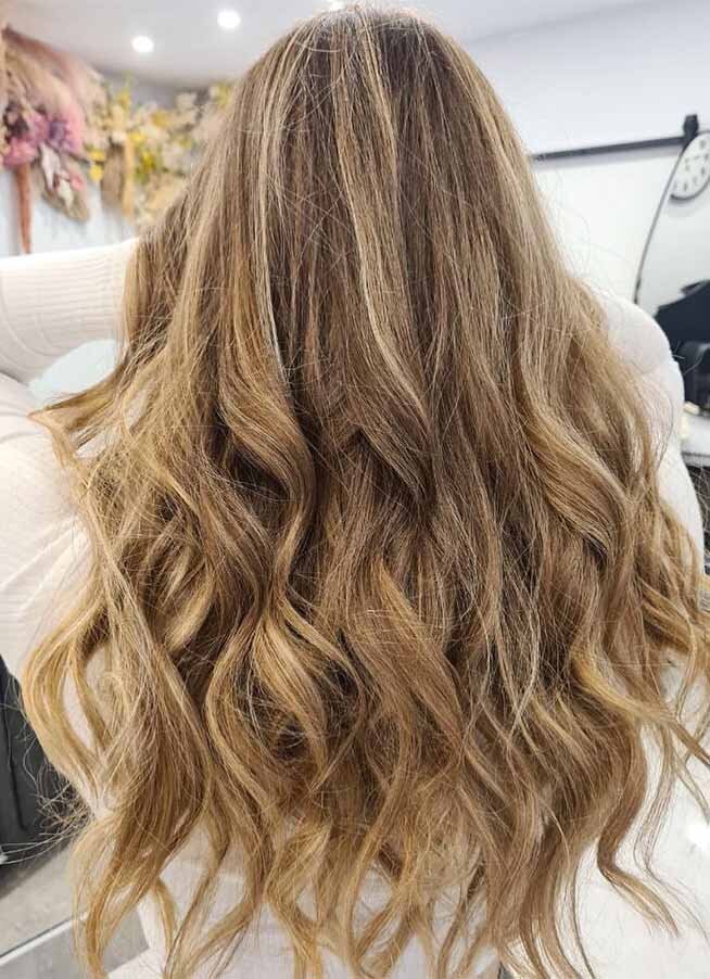 Blonde balayage with soft, natural waves, highlighting professional hair colouring by Sydney’s expert hair colourists at Blake & Kwan.
