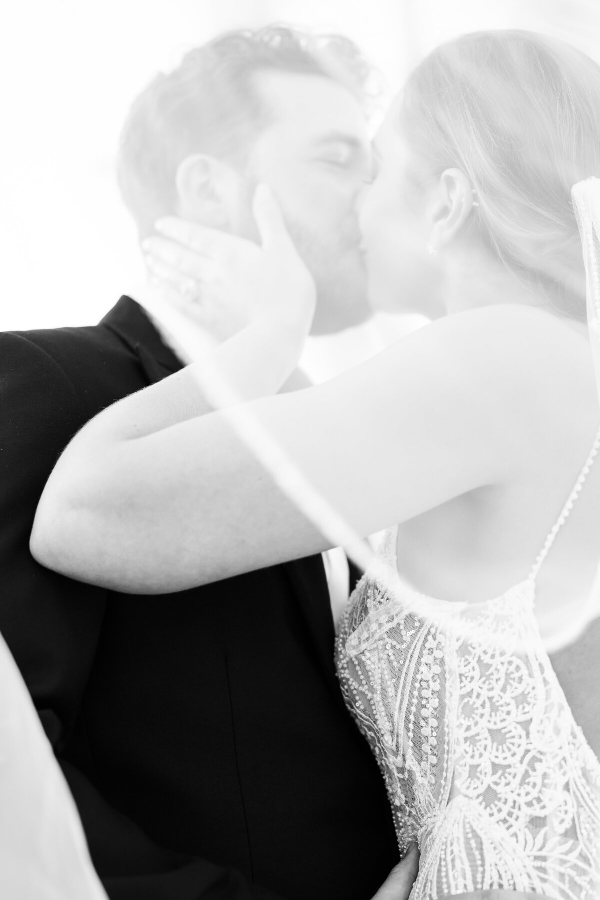 Bride kissing groom under veil at Naples wedding