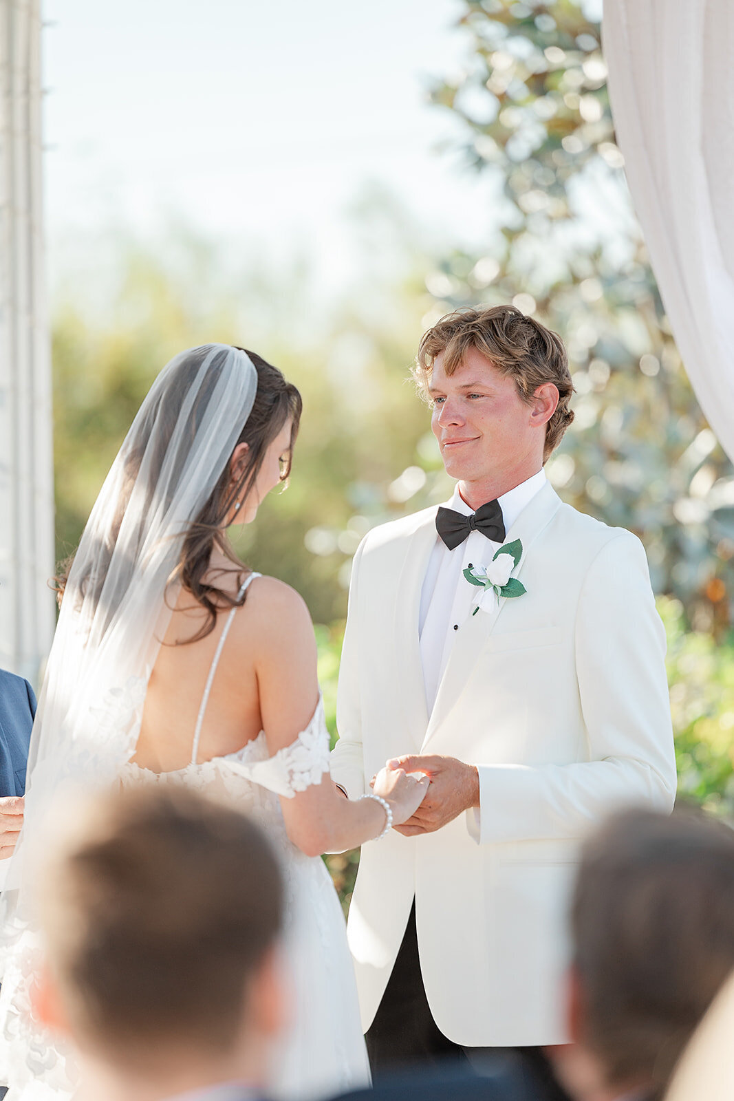 Bride and groom holding hands repeating their vows 