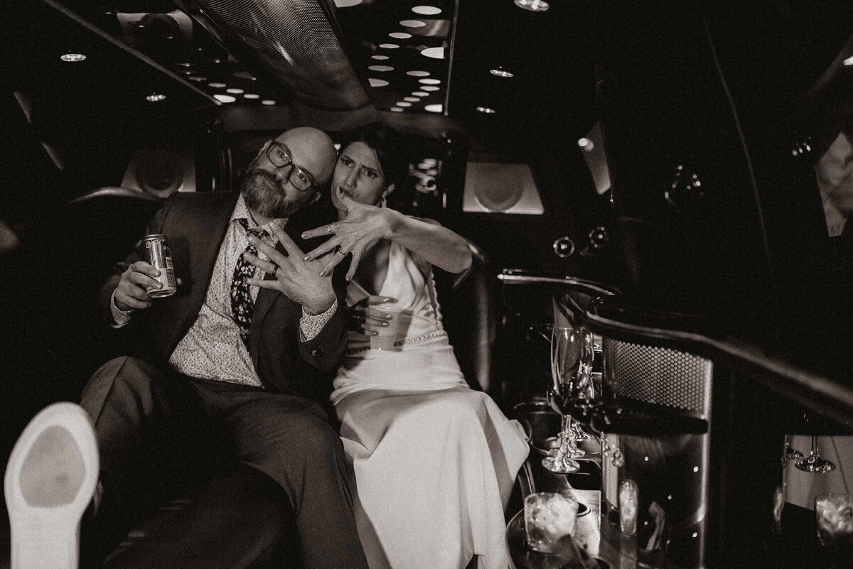 couple showing off rings in limo