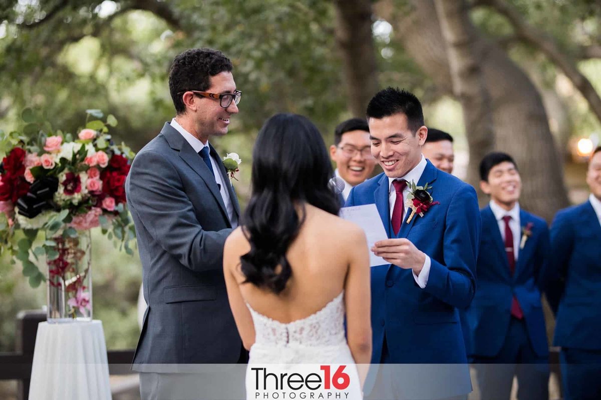 Groom reads his vows while Groomsmen laugh