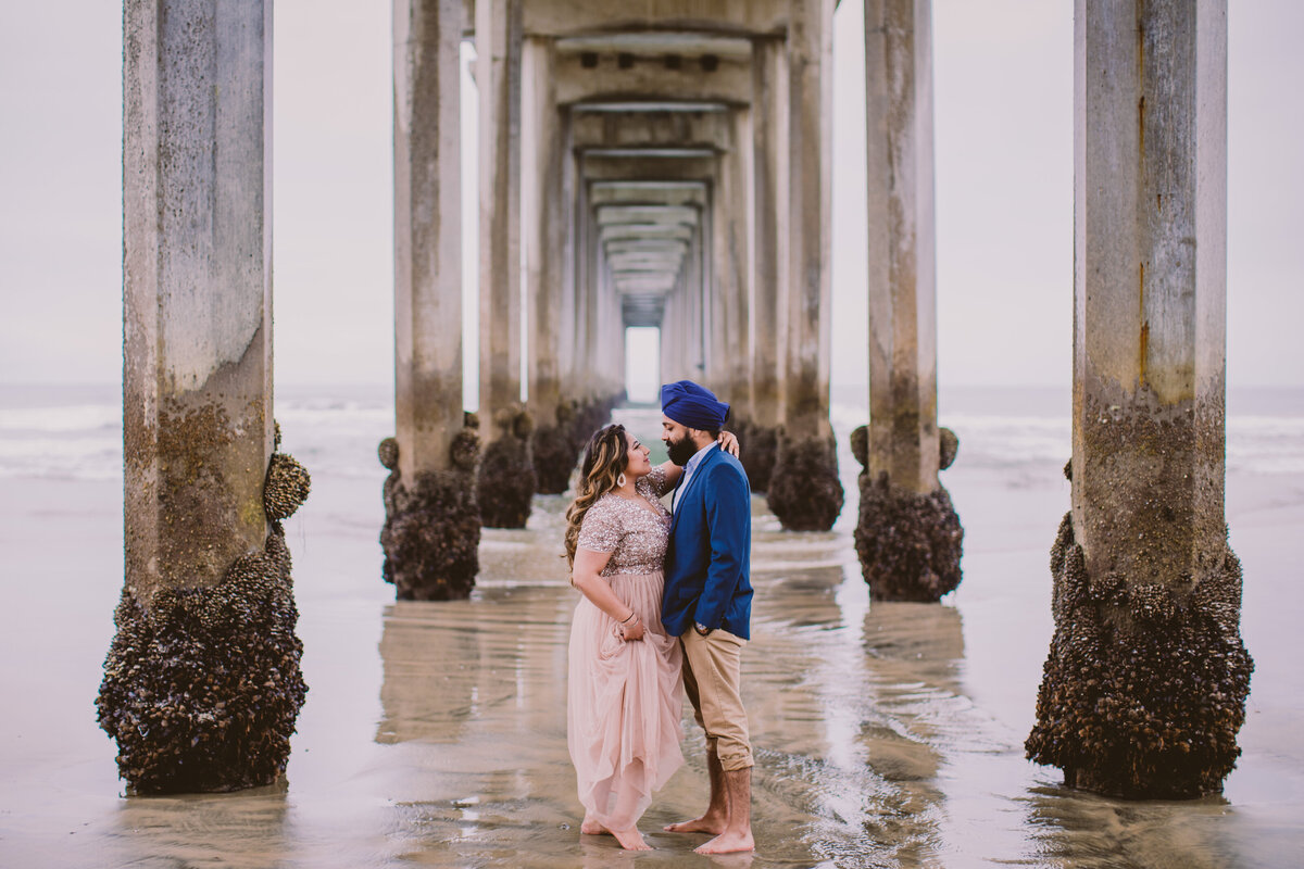 A couple standing under the scripps pier la jolla in san diego california at the beach