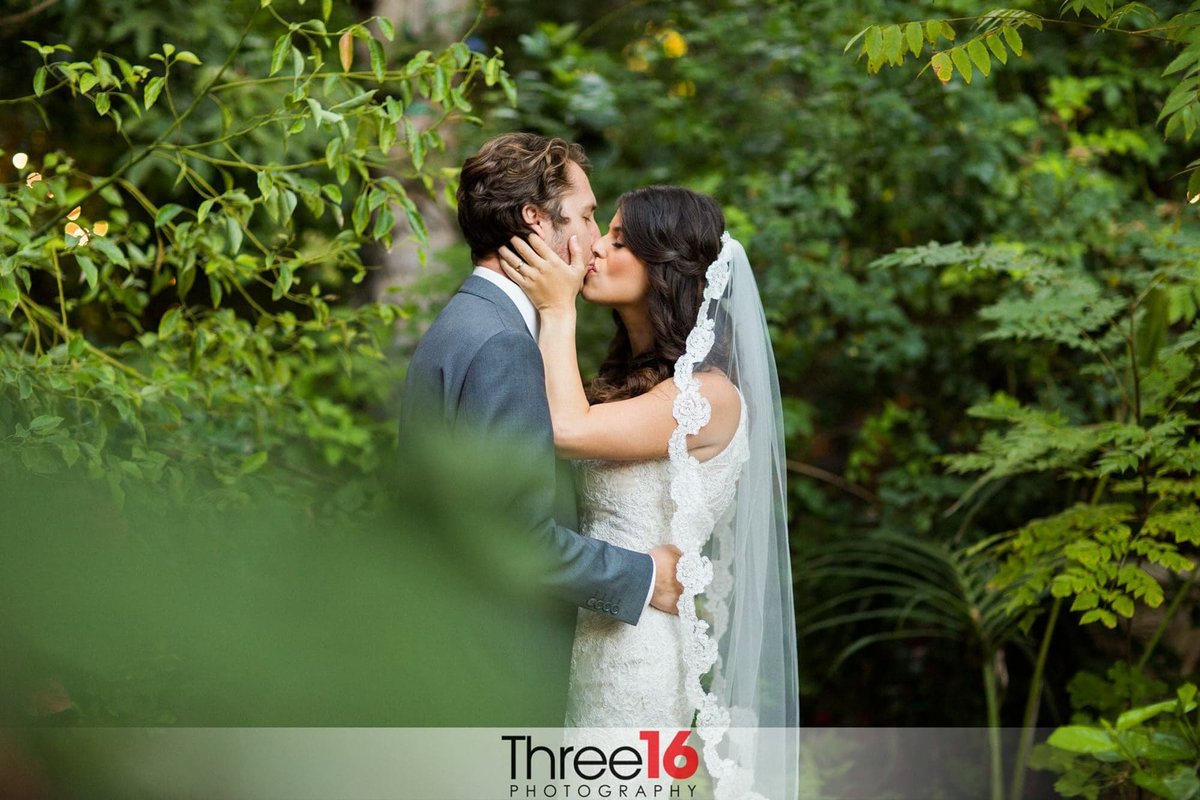 Bride and Groom share a kiss in the gardens