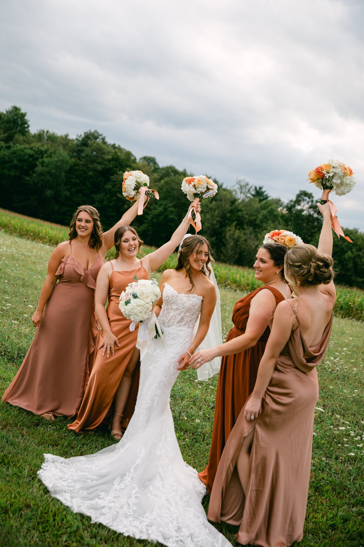 bride-with-bridesmaids-raising-bouquets