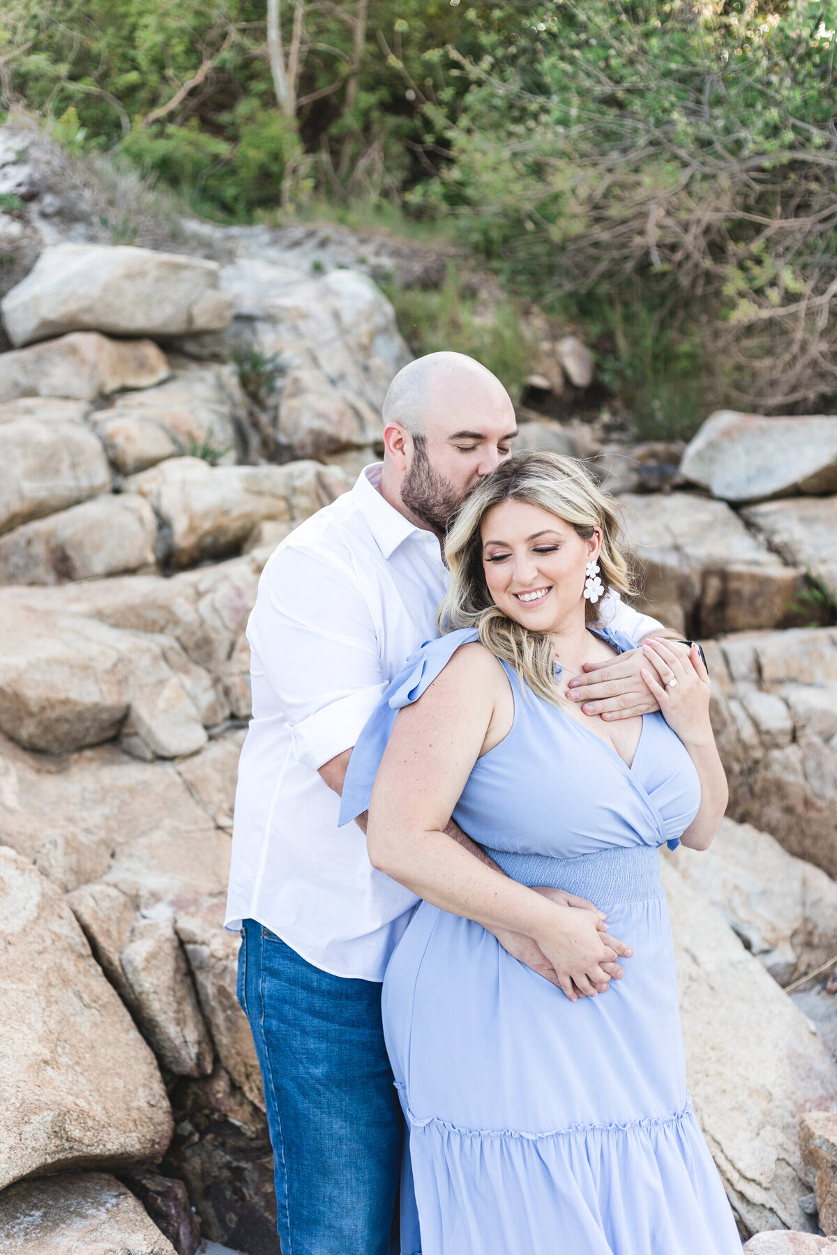 A man loving on his fiancee during their engagement shoot
