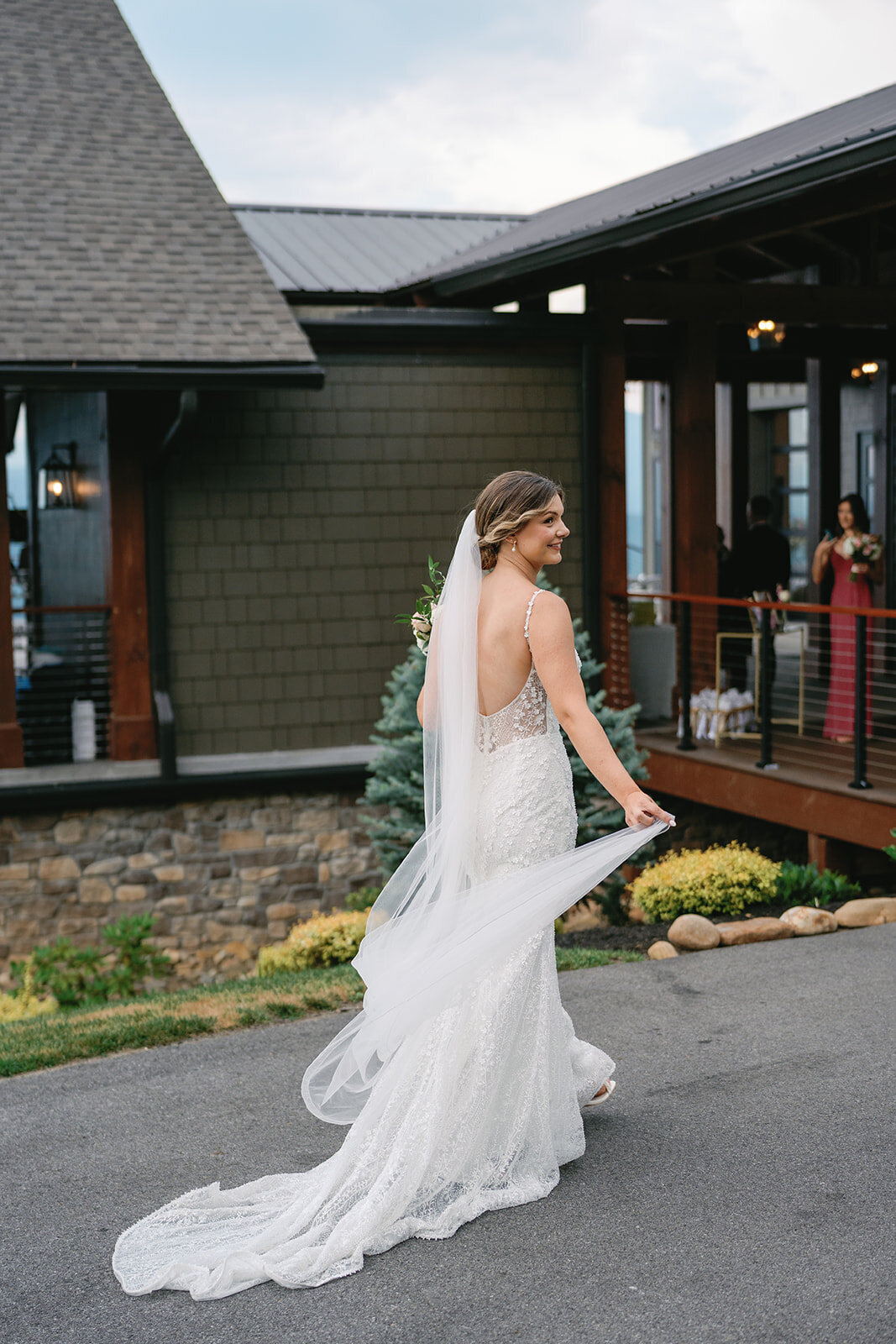 Bride holding her veil as she walks to her wedding ceremony