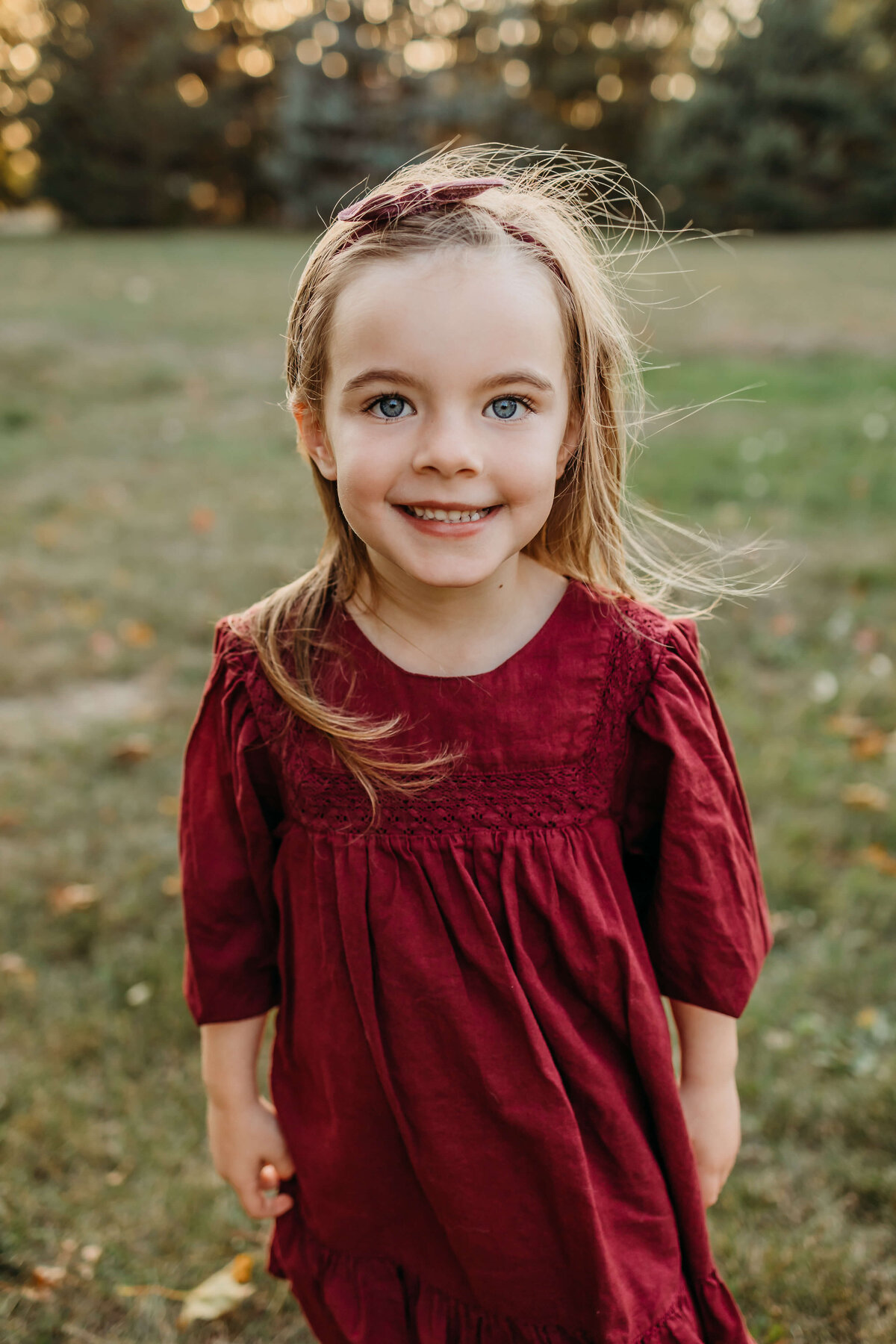 girl in maroon dress at family home outside